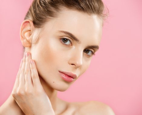 Beauty Concept - Beautiful Woman with Clean Fresh Skin close up on pink studio. Skin care face. Cosmetology.
